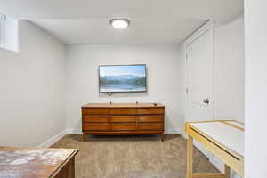 Bedroom featuring light carpet and baseboards