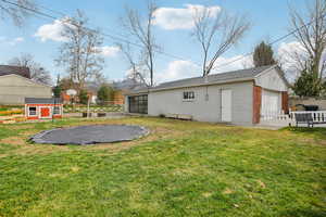 Rear view of property with a detached garage and a storage shed