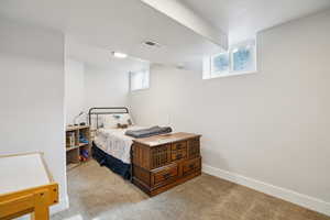 Bedroom featuring light colored carpet and a textured ceiling