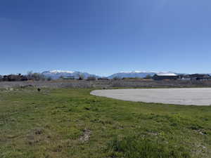 View of green lawn featuring a mountain view and a view of rural / pastoral area