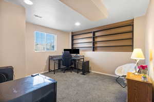 Carpeted office with baseboards and built in shelves