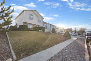 View of side of home featuring a yard and stairs