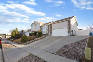 View of front of house with a gate, driveway, a garage, and a residential view