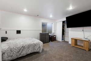 Bedroom featuring a closet and dark colored carpet