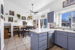 Kitchen featuring light countertops, a peninsula, dishwasher, ceiling fan, and light tile patterned floors