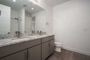 Bathroom with double vanity, a shower stall, and recessed lighting