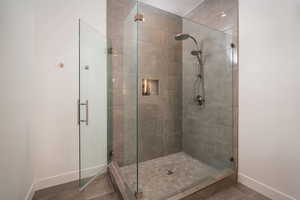 Bathroom featuring a shower stall and baseboards
