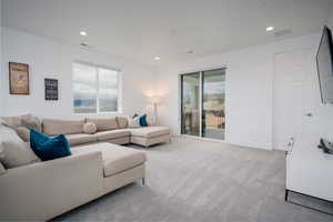Living area featuring light carpet and recessed lighting