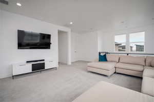 Living area featuring light carpet and recessed lighting