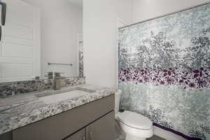 Bathroom featuring a shower with shower curtain and vanity