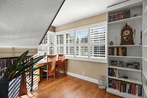 Office area with baseboards and oak floors