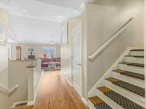 Stairway featuring crown molding, wood finished floors, recessed lighting, and a ceiling fan