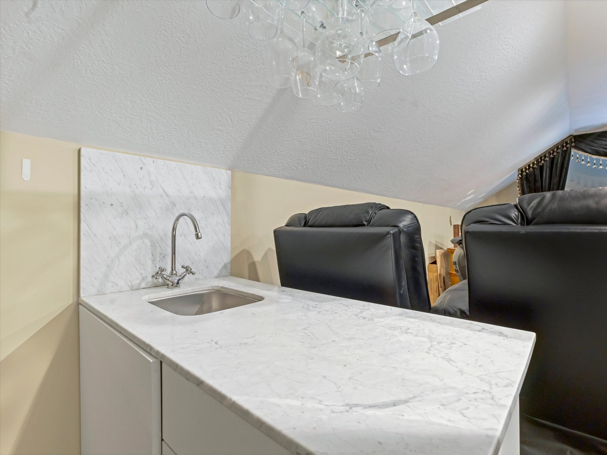 Bar with white cabinets and light stone countertops
