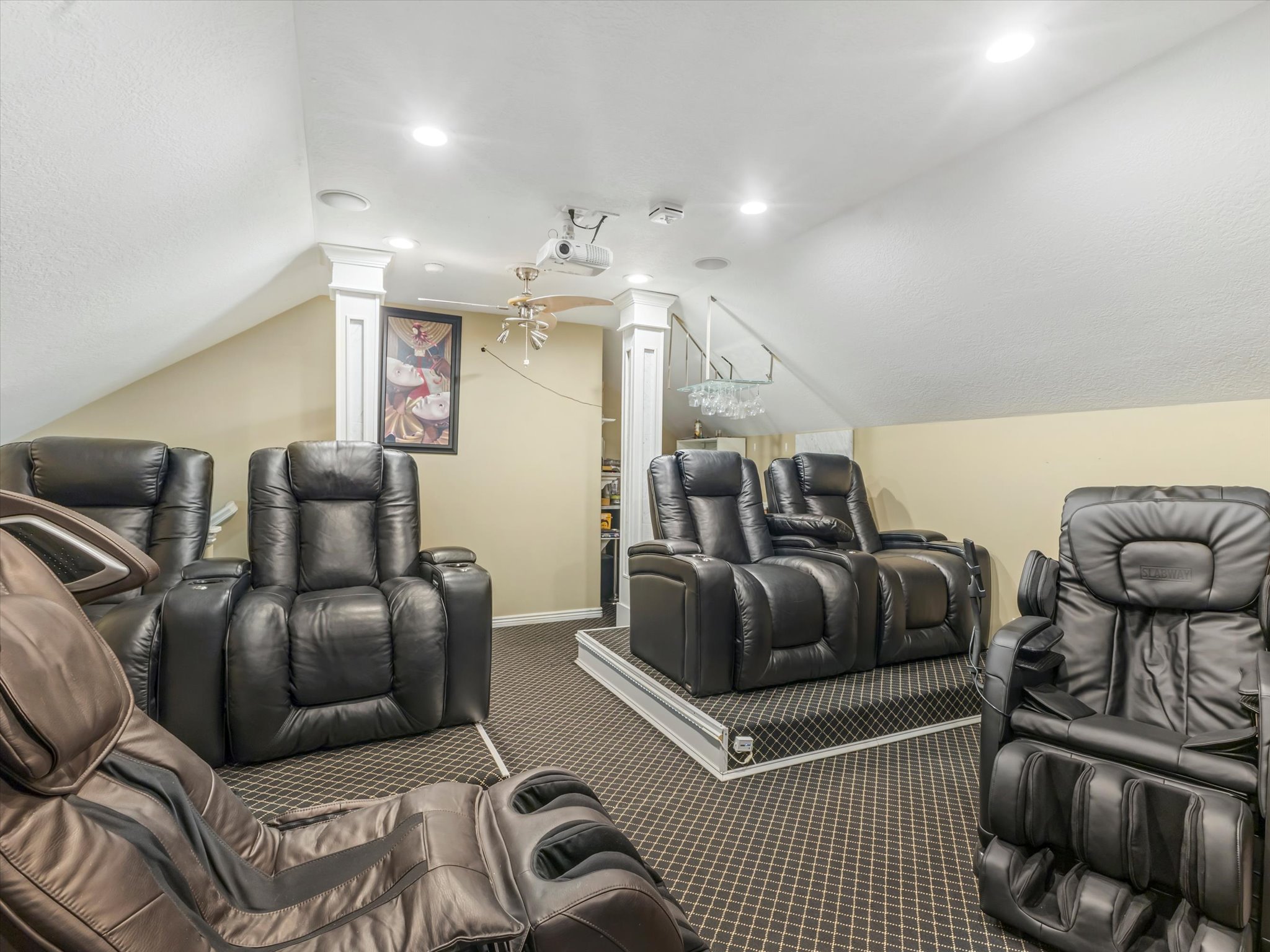 Carpeted home theater room with ornate columns, a ceiling fan, and recessed lighting