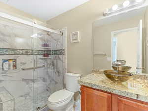 Full bathroom featuring vanity and a marble finish shower