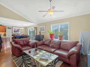 Living area featuring vaulted ceiling, crown molding, hardwood / wood-style flooring, a ceiling fan, and recessed lighting