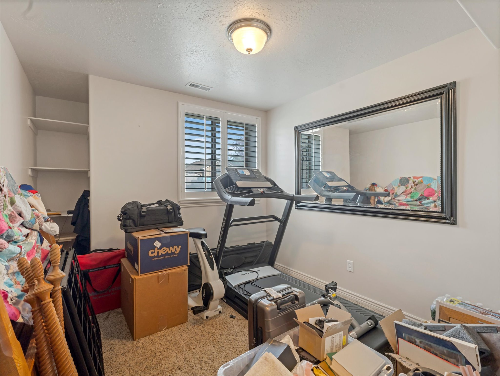 Exercise room featuring a textured ceiling and light colored carpet