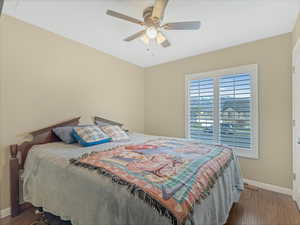 Bedroom with dark wood-style floors and ceiling fan