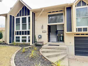 Property entrance with brick siding and a garage