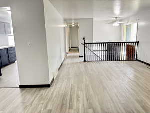 Spare room with light wood-style flooring, a textured ceiling, and ceiling fan