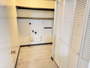 Laundry area with light wood finished floors and hookup for a gas dryer