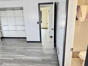 Unfurnished bedroom featuring light wood finished floors and a closet