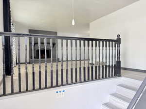 Stairs featuring baseboards and a fireplace with raised hearth
