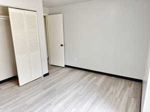 Unfurnished bedroom with a closet and light wood-style floors