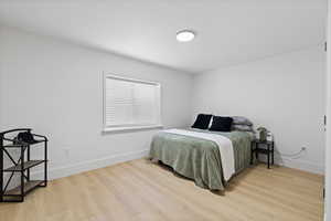 Basement bedroom featuring LVP flooring and light paint