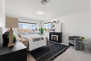 Primary bedroom with large windows, custom roller shades, light paint and plush carpet