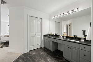 Ensuite bathroom with tile floors, double vanity with quartz counters and in-bathroom linen closet