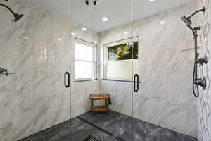 Custom tiled shower with dual shower heads and euro-glass surround