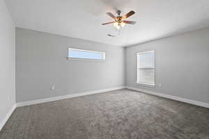 ADU primary bedroom with a ceiling fan, natural light, two-tone paint and carpet flooring