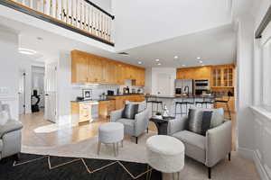 Open concept living space featuring family room and large kitchen, light paint, mix of carpet and tile flooring, can lighting and dark quartz countertops