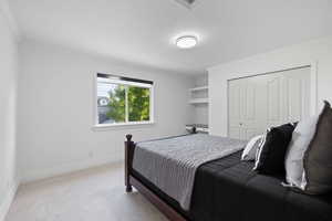 Second floor bedroom featuring plush carpet, light paint, custom roller shades and built-in desk