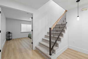 Basement stairwell and landing with light LVP flooring