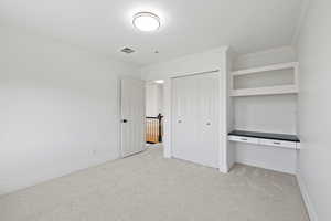 Second floor bedroom featuring plush carpet, closet, and built-in desk