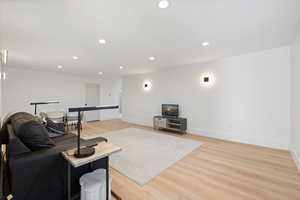 Oversized basement living room featuring LVP flooring and light paint