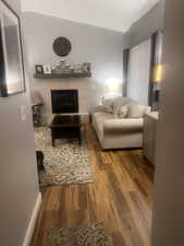 Living area featuring dark wood-style flooring and a fireplace