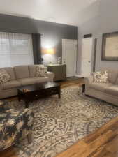 Living area with wood finished floors and lofted ceiling