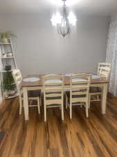 Dining space featuring dark wood-style floors and a chandelier