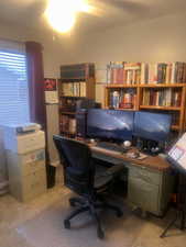Home office featuring a ceiling fan and light carpet