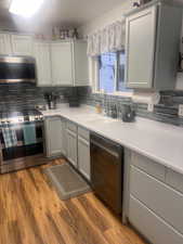 Kitchen with stainless steel appliances, backsplash, and light countertops