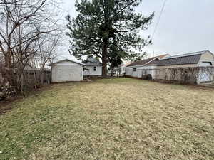 Fenced backyard with an outdoor structure