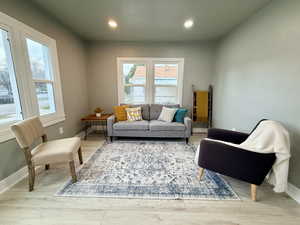 Living area with light wood finished floors and recessed lighting
