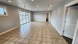 Spare room featuring recessed lighting, a textured ceiling, and light tile patterned floors
