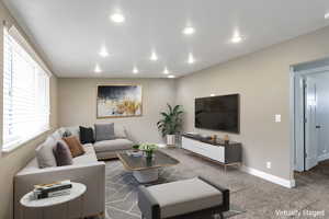 Carpeted living room with recessed lighting. *This photo is virtually staged*