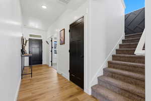 Foyer featuring stairs and light wood finished floors