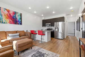 Living area featuring light wood-type flooring and recessed lighting