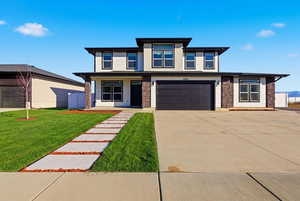 Grass Virtually Added - Prairie-style house with a porch, concrete driveway, a garage, a front yard, and stone siding